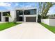 Modern two-story home with sleek design, dark window frames, and a spacious driveway at 7608 Antilla St, Tampa, FL 33625