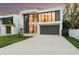 Modern two-story home boasting large windows, a grey two-car garage, and minimalist landscaping at 7608 Antilla St, Tampa, FL 33625