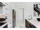 Modern kitchen features stainless steel refrigerator, white cabinets, marble flooring, and access to the staircase at 7608 Antilla St, Tampa, FL 33625
