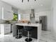 Contemporary kitchen featuring sleek white cabinetry, an island with seating, and stainless steel appliances at 7608 Antilla St, Tampa, FL 33625
