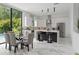 Modern kitchen and dining area with large windows, an island with bar stools, and marble flooring at 7608 Antilla St, Tampa, FL 33625
