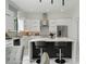 Modern kitchen featuring sleek white cabinetry, quartz countertops and an island with breakfast bar seating at 7608 Antilla St, Tampa, FL 33625