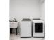 Functional laundry room featuring modern washer and dryer set with a convenient utility sink at 7608 Antilla St, Tampa, FL 33625
