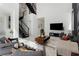 Bright, modern living room featuring marble floors, comfortable seating, and an open staircase at 7608 Antilla St, Tampa, FL 33625