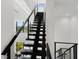 Sleek, modern black staircase with minimalist design and natural light from large adjacent windows at 7608 Antilla St, Tampa, FL 33625