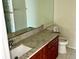 Bathroom with a granite vanity, a wood cabinet, and a large mirror reflecting natural light at 8608 Twin Farms Pl, Tampa, FL 33635