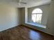 Bedroom featuring wood-look flooring, an arched window and a ceiling fan at 8608 Twin Farms Pl, Tampa, FL 33635