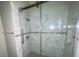 Modern shower with glass sliding doors, marble walls, and sleek fixtures, offering a spa-like experience at 8608 Twin Farms Pl, Tampa, FL 33635