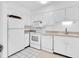 Bright kitchen featuring white appliances, white cabinets, and tile flooring offering a clean aesthetic at 10365 Paradise Blvd # 4, Treasure Island, FL 33706