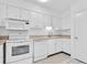 Bright kitchen with white appliances and tile flooring at 10365 Paradise Blvd # 4, Treasure Island, FL 33706