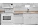 Bright kitchen featuring a range, microwave, dishwasher and white cabinets at 10365 Paradise Blvd # 4, Treasure Island, FL 33706