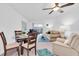 Bright living room featuring neutral furniture, a ceiling fan, and sliding glass doors to the balcony at 10365 Paradise Blvd # 4, Treasure Island, FL 33706