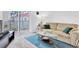 Neutral living room featuring a glass coffee table, sofa, and access to the balcony through sliding glass doors at 10365 Paradise Blvd # 4, Treasure Island, FL 33706