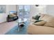 Comfortable living room featuring a cozy sofa, glass coffee table, and sliding glass doors to the balcony at 10365 Paradise Blvd # 4, Treasure Island, FL 33706
