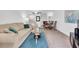 Inviting living room featuring a comfortable sofa, glass coffee table, and open access to the dining area and kitchen at 10365 Paradise Blvd # 4, Treasure Island, FL 33706
