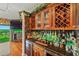 Elegant wet bar with wine storage, glassware cabinets, and a granite countertop at 1200 Country Club Dr # 5404, Largo, FL 33771