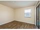Bright bedroom with wood-look flooring, window with blinds and sliding glass door access to patio at 12293 Sailwinds Dr # 206, Largo, FL 33773