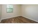 Inviting bedroom with wood-look floors, a window with blinds, and neutral paint at 12293 Sailwinds Dr # 206, Largo, FL 33773