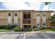 A two-story condo building with parking in front and green landscaping at 12293 Sailwinds Dr # 206, Largo, FL 33773