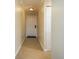 Hallway view with beige flooring, white trim, and a front door at the end at 12293 Sailwinds Dr # 206, Largo, FL 33773