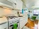 Compact kitchen featuring white cabinetry, modern appliances, and a dining nook at 130 4Th N Ave # 608, St Petersburg, FL 33701
