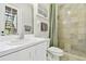 Bathroom featuring a sink, white cabinetry, beige and green tiling, shower and wood trim at 13310 Waterford Run Dr, Riverview, FL 33569