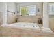 This bathroom features a built in bathtub with elegant tiling and columns on either side at 13310 Waterford Run Dr, Riverview, FL 33569
