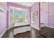 Bright purple bedroom featuring a daybed, hardwood floors, large windows and white shelves at 13310 Waterford Run Dr, Riverview, FL 33569