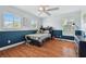 Cozy bedroom with hardwood floors, accent wall, and large windows for a bright and inviting space at 13310 Waterford Run Dr, Riverview, FL 33569