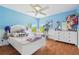 Charming blue bedroom with natural light, window seats and hardwood floors for a bright, cozy feel at 13310 Waterford Run Dr, Riverview, FL 33569