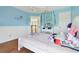 A serene blue bedroom, featuring bead-board wainscotting, a vanity, and an open doorway at 13310 Waterford Run Dr, Riverview, FL 33569