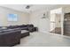 Versatile bonus room with carpet, featuring a comfortable sectional sofa and a ceiling-mounted projector at 13310 Waterford Run Dr, Riverview, FL 33569