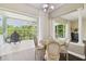 Bright dining area with dark wood floors, a round table, and sliding doors to the screened outdoor patio at 13310 Waterford Run Dr, Riverview, FL 33569