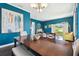 Dining room featuring blue walls, wood floors, and a dining table with seating at 13310 Waterford Run Dr, Riverview, FL 33569