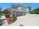 Three-car garage with gray doors and a long concrete driveway at 13310 Waterford Run Dr, Riverview, FL 33569