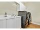 Laundry room featuring a sink, cabinets, stainless steel washer and dryer, and wood flooring at 13310 Waterford Run Dr, Riverview, FL 33569