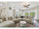 Bright living room with sectional sofa, ceiling fan, and sliding door to screened outdoor living area at 13310 Waterford Run Dr, Riverview, FL 33569