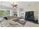 Comfortable living room with a large sectional sofa, ceiling fan, and view of the screened patio at 13310 Waterford Run Dr, Riverview, FL 33569