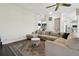 Spacious living room with a large sectional sofa, ceiling fan and view to the staircase at 13310 Waterford Run Dr, Riverview, FL 33569
