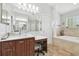 This elegant bathroom offers a marble-look vanity, and a tub with surrounding windows for lots of light at 13310 Waterford Run Dr, Riverview, FL 33569