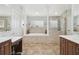Bright bathroom features a bathtub surrounded by columns, a glass shower, and a marble-look vanity at 13310 Waterford Run Dr, Riverview, FL 33569