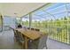 Outdoor patio area with a long wooden table and seating for eight with a screen enclosure at 13310 Waterford Run Dr, Riverview, FL 33569