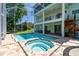 This screened-in pool and jacuzzi has brick trim and patio furniture outside the screen at 13310 Waterford Run Dr, Riverview, FL 33569