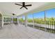 This screened porch offers a place to relax with outdoor furniture, ceiling fans, and a beautiful view of the trees at 13310 Waterford Run Dr, Riverview, FL 33569