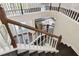 Well-lit staircase with dark wood steps and white railings, offering a view of the foyer at 13310 Waterford Run Dr, Riverview, FL 33569
