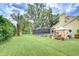 Spacious backyard featuring a large lawn, tropical landscaping, a pool, and patio area at 14119 Stonegate Dr, Tampa, FL 33624