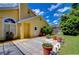 Sunny backyard with a gray paver patio, potted plants, and manicured grass at 14119 Stonegate Dr, Tampa, FL 33624