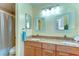 Well-lit bathroom featuring a double sink vanity with granite countertops and decorative mirrors at 14119 Stonegate Dr, Tampa, FL 33624