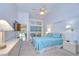 Bright bedroom featuring a ceiling fan, white walls, and a view of the screened-in pool area at 14119 Stonegate Dr, Tampa, FL 33624