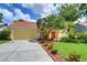 Inviting single-story home showcasing well-maintained landscaping, a driveway, and a cheerful yellow exterior at 14119 Stonegate Dr, Tampa, FL 33624